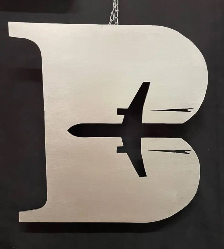 A large metal letter with an airplane on it.