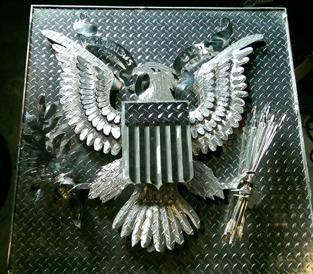 A metal eagle with an american flag on it's wings.