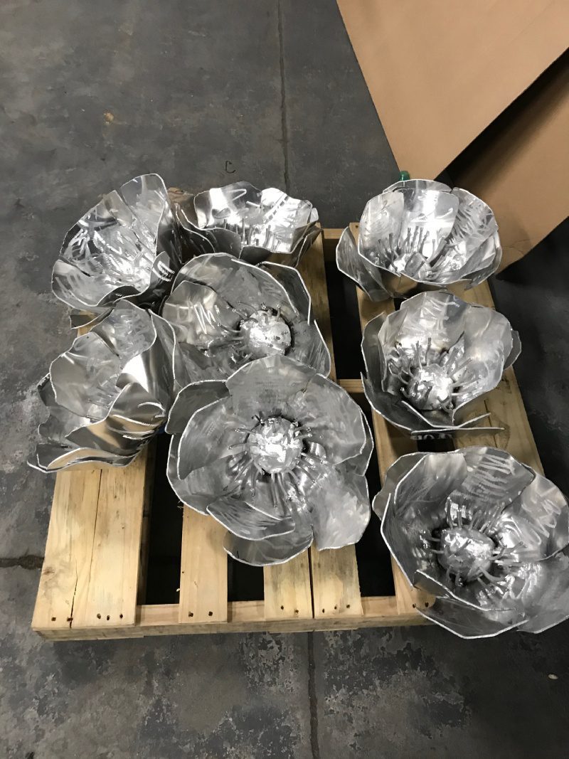 A pallet of aluminum flowers sitting on top of pallets.