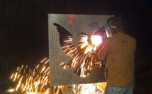 A person welding with sparks flying from their hands.